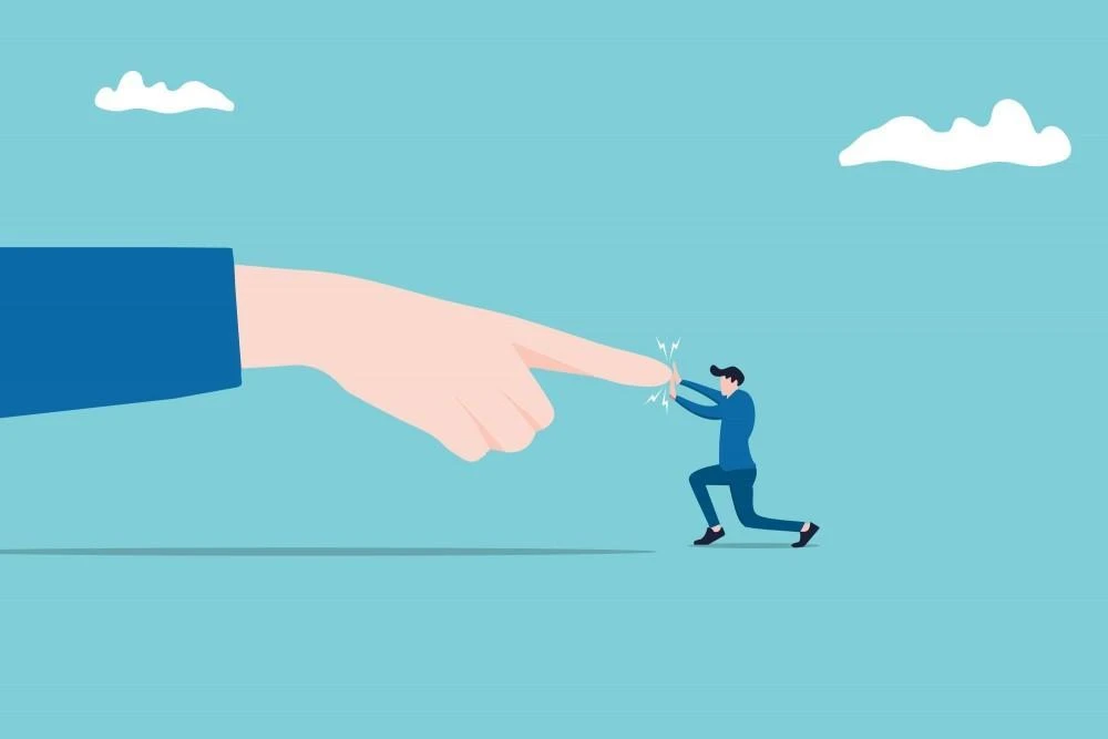 Illustration of a giant hand reaching towards a small person who appears to be pushing against the fingertip, with a blue background and a few clouds.